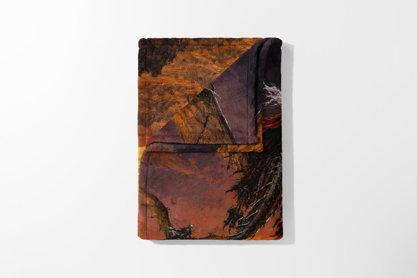 Folded blanket featuring a dragon in a dramatic, fiery landscape scene.