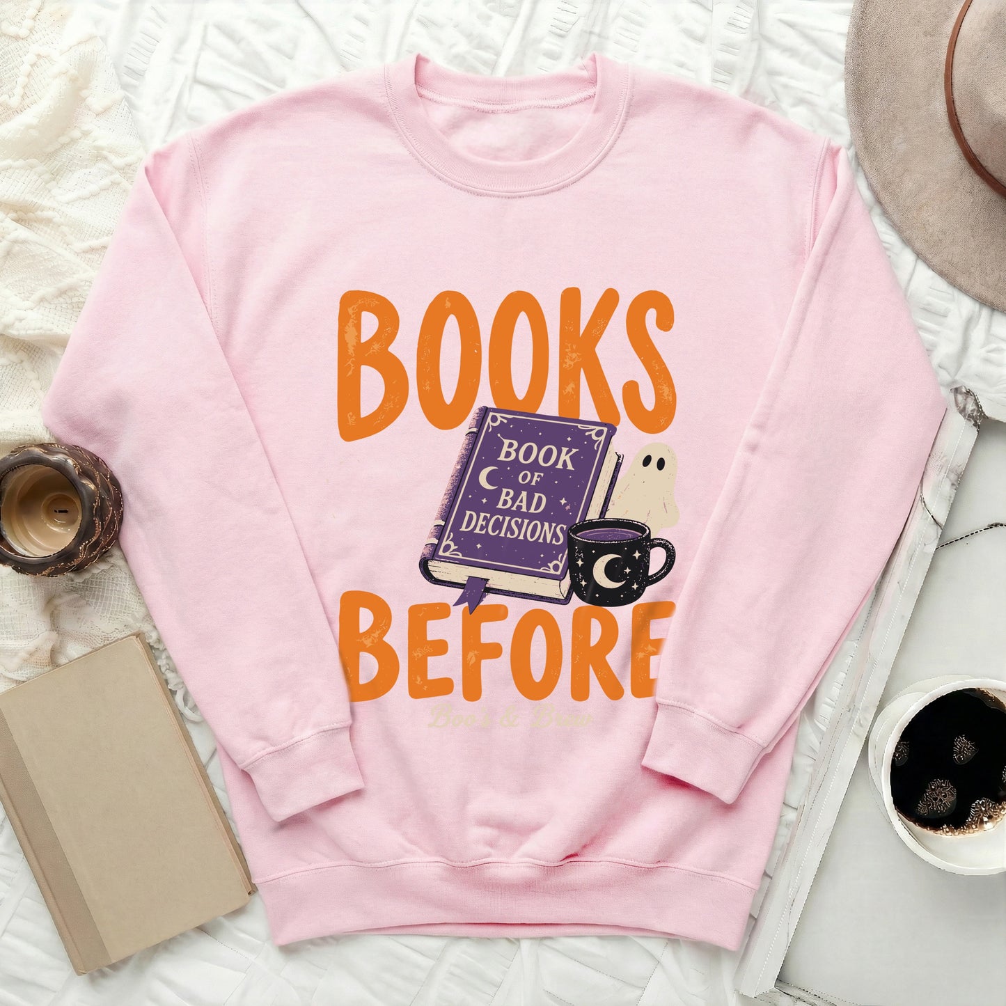 Pink sweatshirt with "Books Before Bad Decisions" graphic featuring a book and ghost.