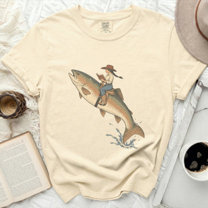 Illustration of a woman in a cowboy hat riding a rainbow trout while reading a book.