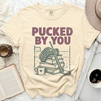 Cream t-shirt with "Pucked By You" text and hockey gear illustration.