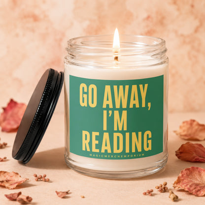 Lit candle in glass jar with "GO AWAY, I'M READING" text.