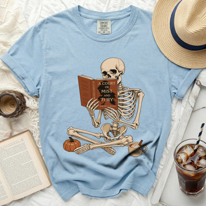 Skeleton reading "A Court of Mist and Fury" book on light blue t-shirt.
