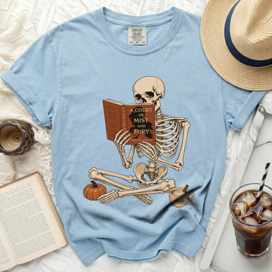 Skeleton reading "A Court of Mist and Fury" book on light blue t-shirt.