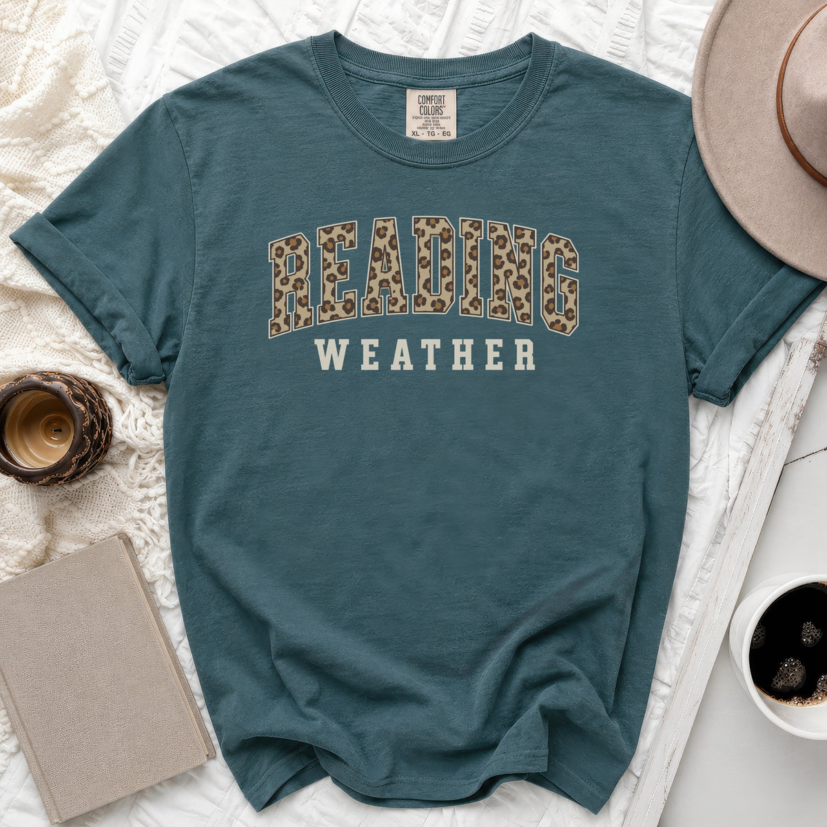 Teal t-shirt with leopard print "READING" and "WEATHER" text.