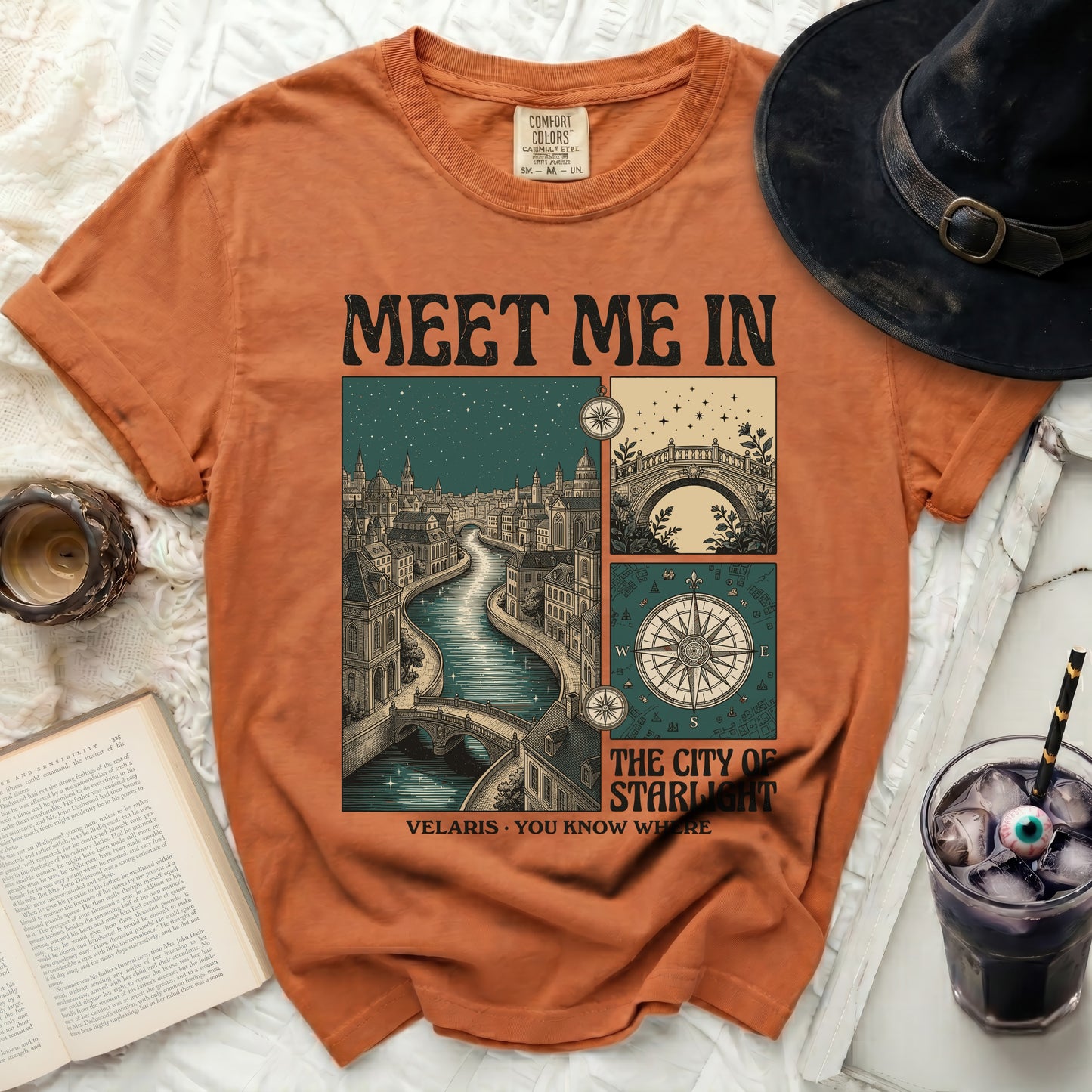 Orange t-shirt with "Meet Me In Velaris You Know Where" graphic featuring a city and compass.