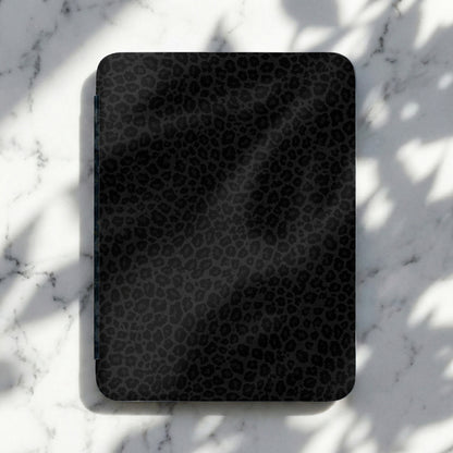 Dark gray black leopard print electronic device cover on marble surface.