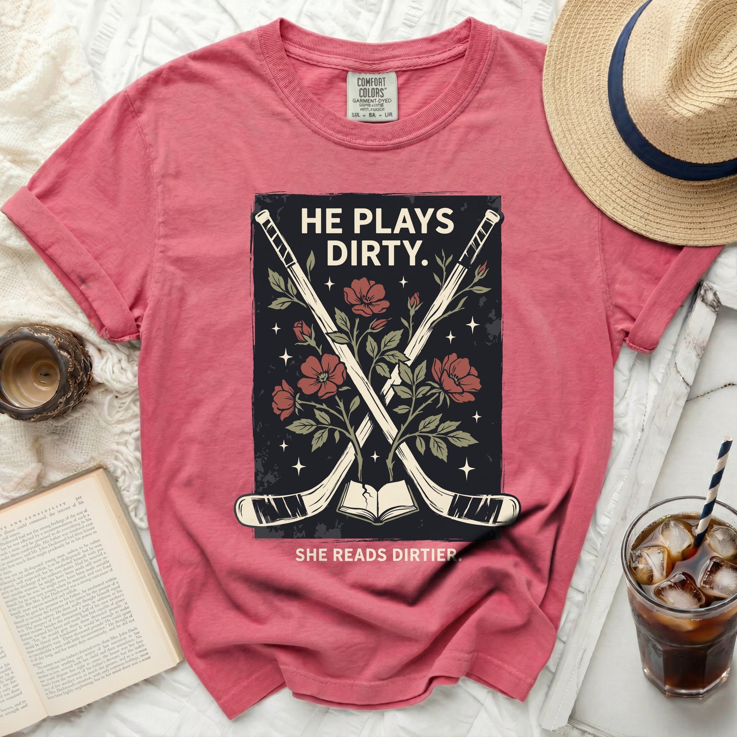 T-shirt with hockey sticks, book, and flowers; "HE PLAYS DIRTY. SHE READS DIRTIER."