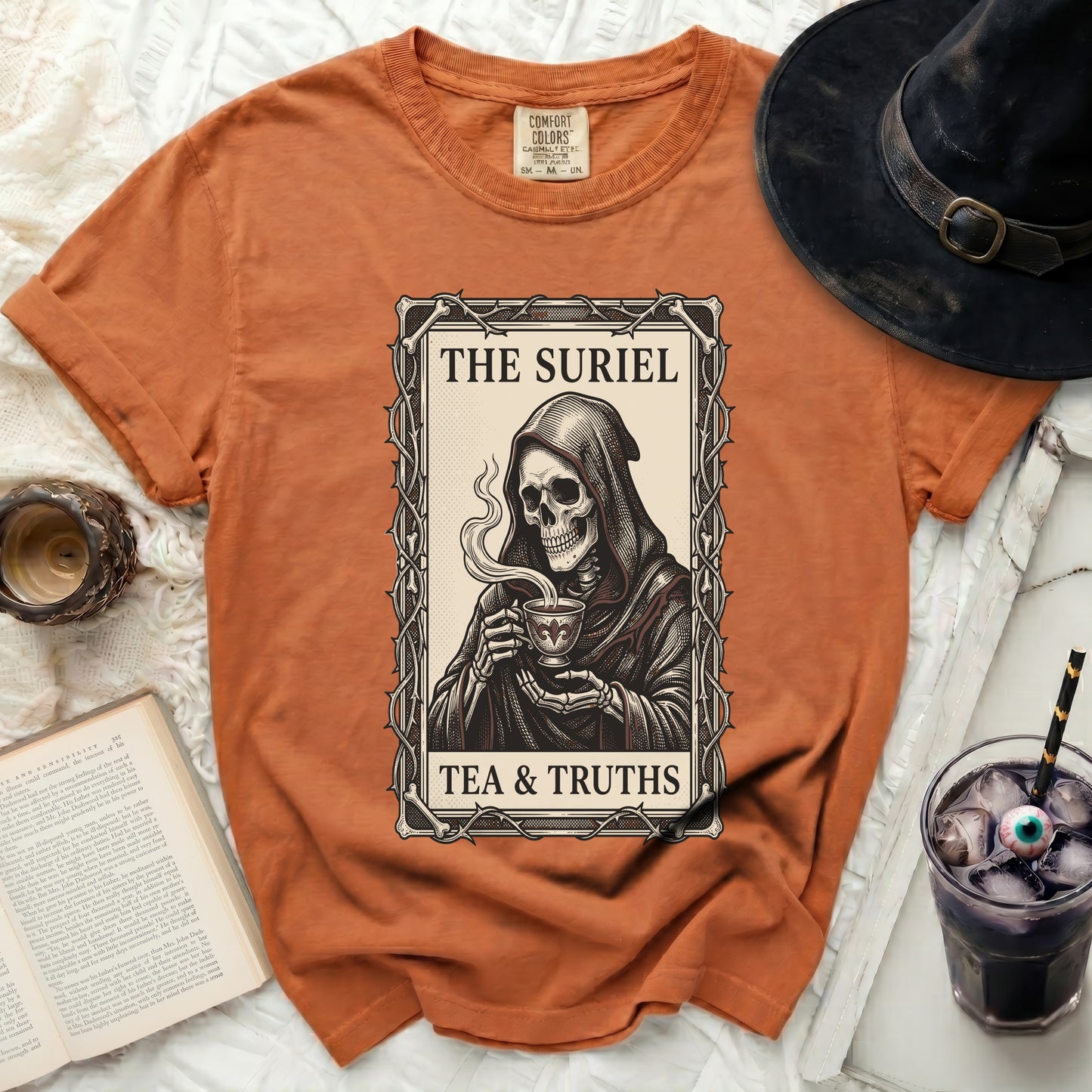 Orange t-shirt with grim reaper skeleton drinking tea and text "The Suriel Tea & Truths".