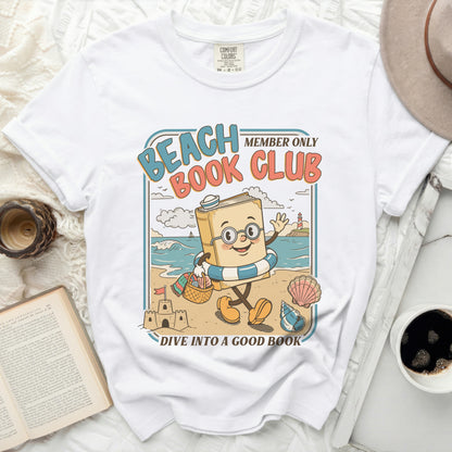 White t-shirt with "Beach Book Club" and a book character on the beach.