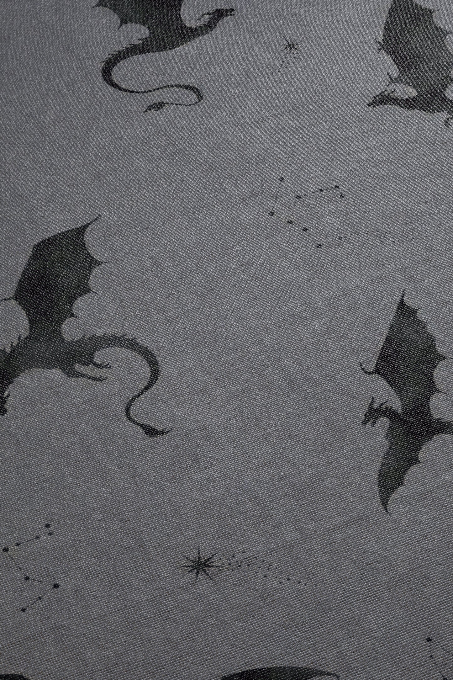 a pattern of black silhouettes of dragons against a gray background.