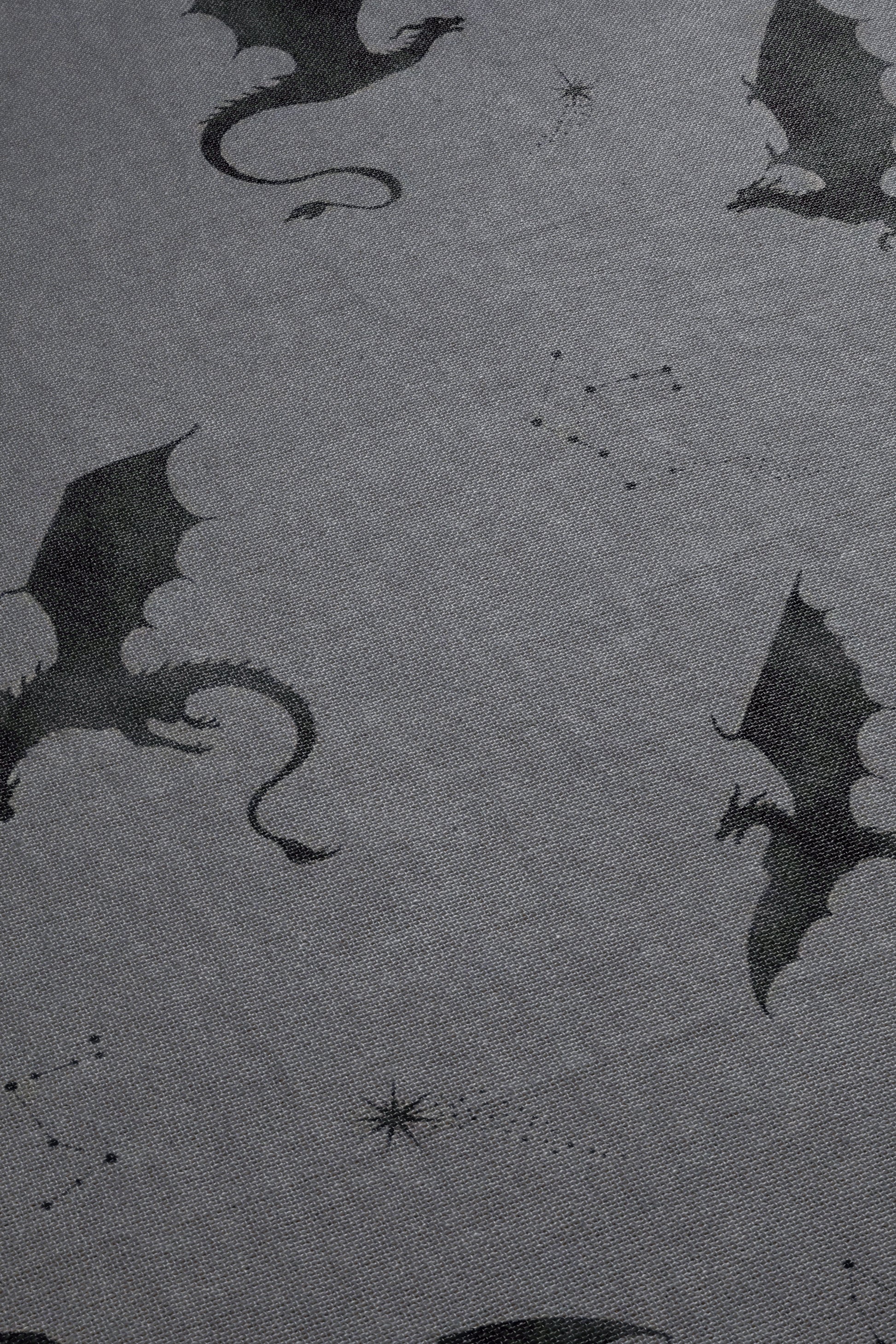 a pattern of black silhouettes of dragons against a gray background.