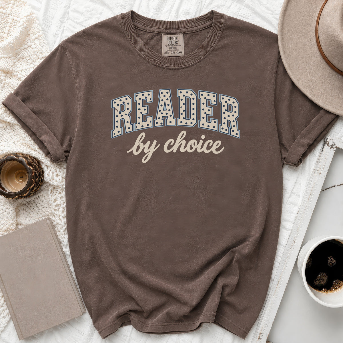 Brown t-shirt with "READER by choice" text, featuring a hat and coffee.