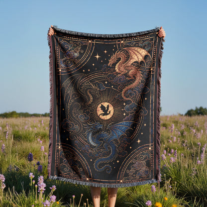 A person is holding up a large, intricately designed blanket with a dragon and star motif, standing in a field of purple flowers.