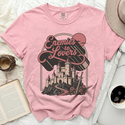 Pink Comfort Colors t-shirt with "Enemies to Lovers" castle graphic.