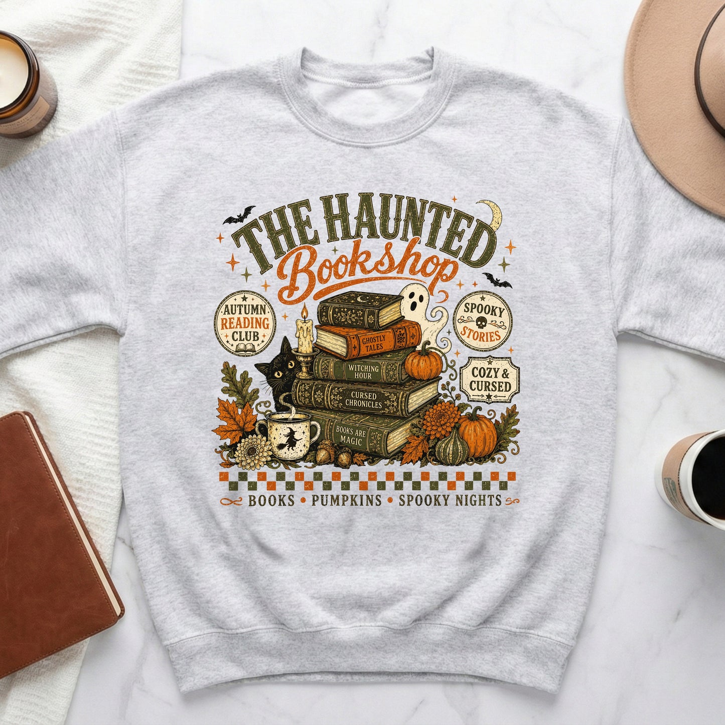 The Haunted Bookshop graphic on a gray sweatshirt with books, ghost, cat, and pumpkins.