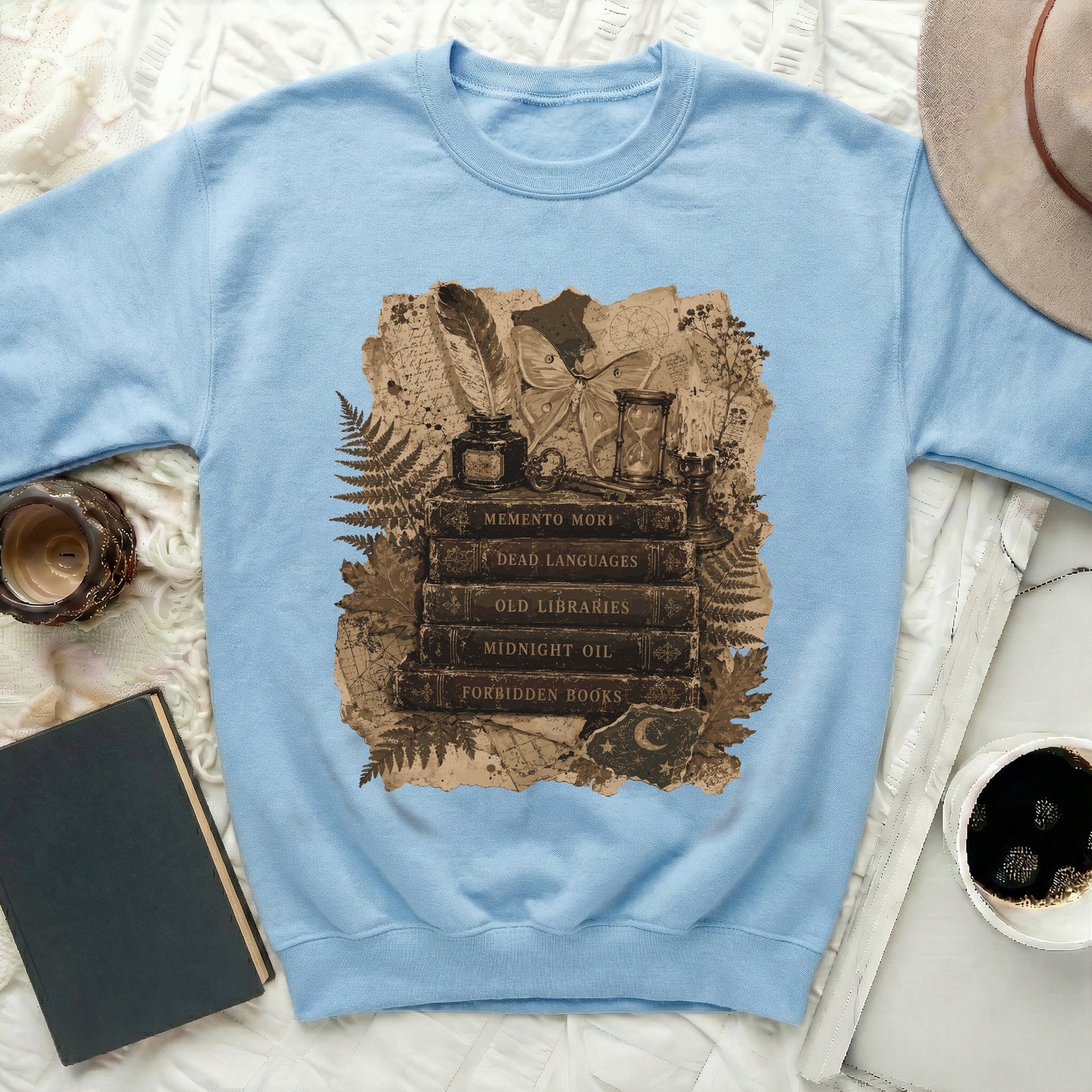 Light blue sweatshirt with Memento Mori stack of books, moth, and hourglass print.