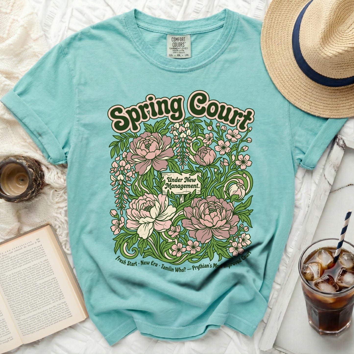 Aqua t-shirt with "Spring Court Under New Management" floral graphic.