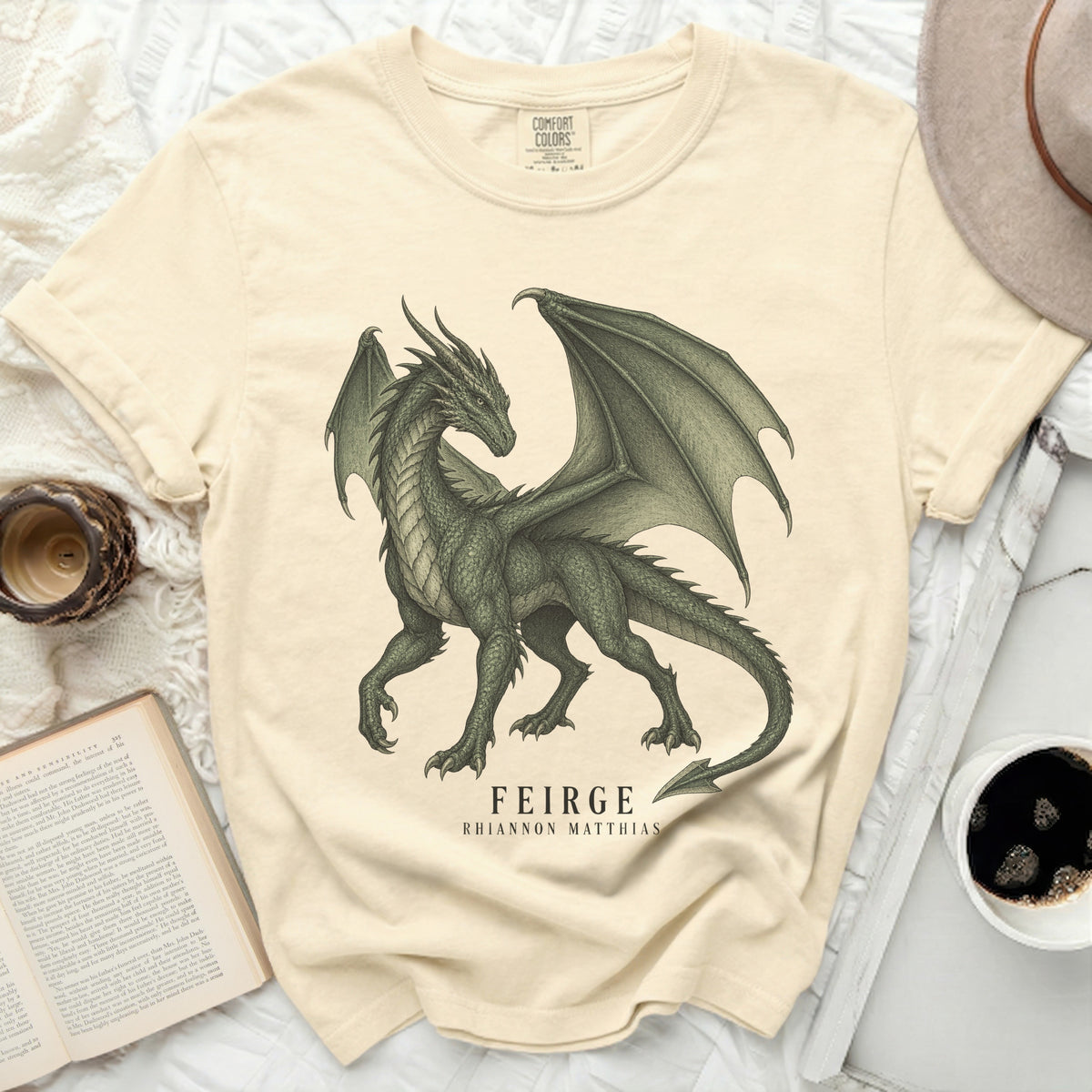 Cream t-shirt with a detailed green dragon graphic and text "FEIRGE RHIANNON MATTHIAS".