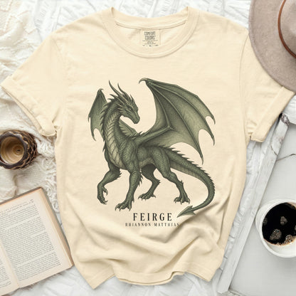 Cream t-shirt with a detailed green dragon graphic and text "FEIRGE RHIANNON MATTHIAS".