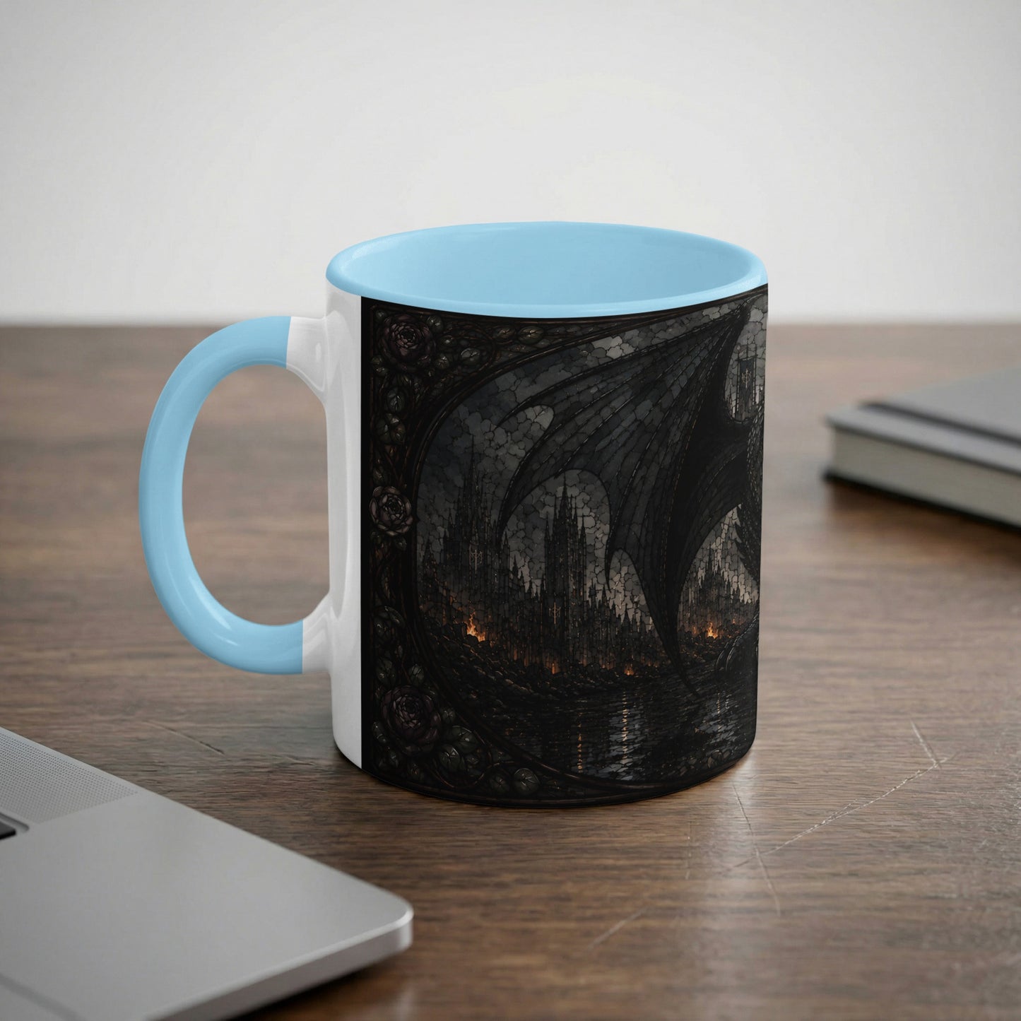 White mug with light blue handle featuring a dark, gothic castle and dragon wing design.