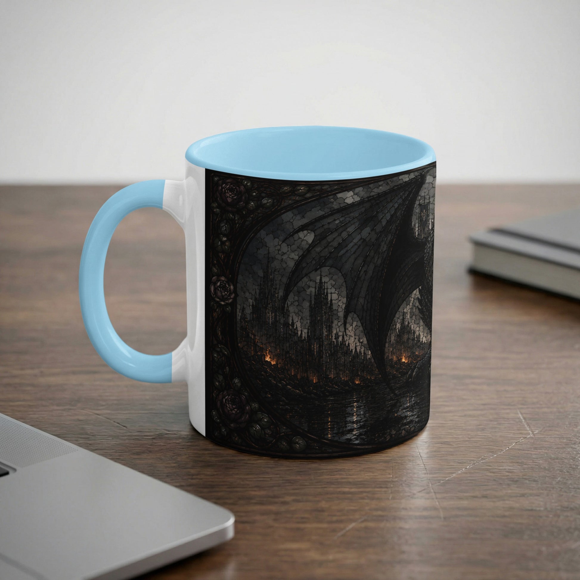 White mug with light blue handle featuring a dark, gothic castle and dragon wing design.