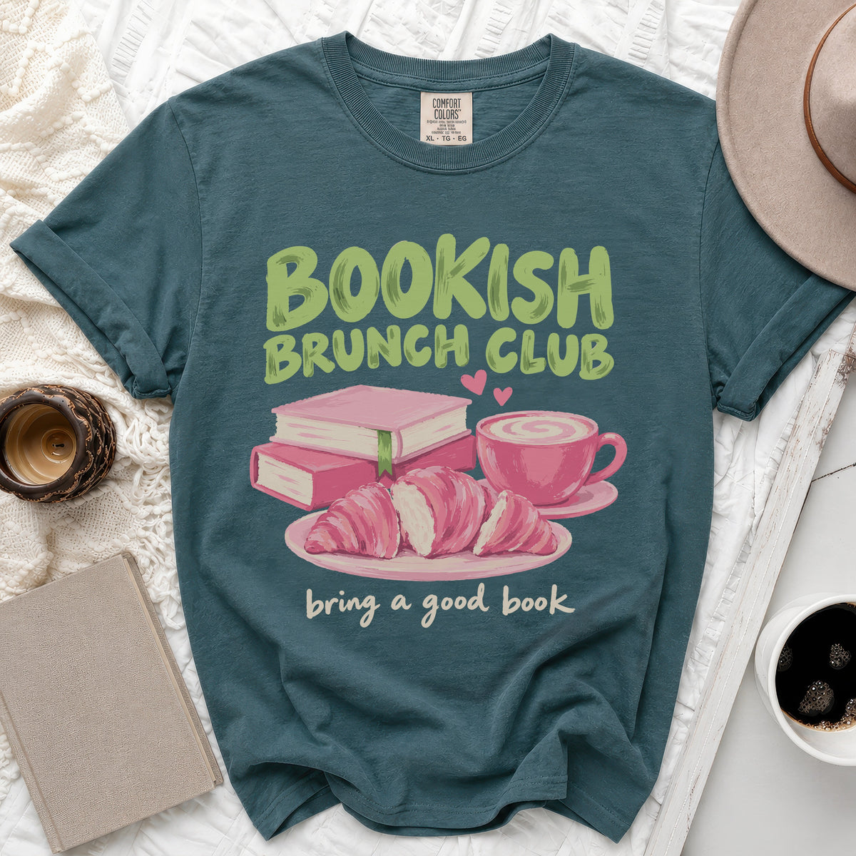 Dark teal t-shirt with "Bookish Brunch Club" and a book, croissants, and coffee graphic.