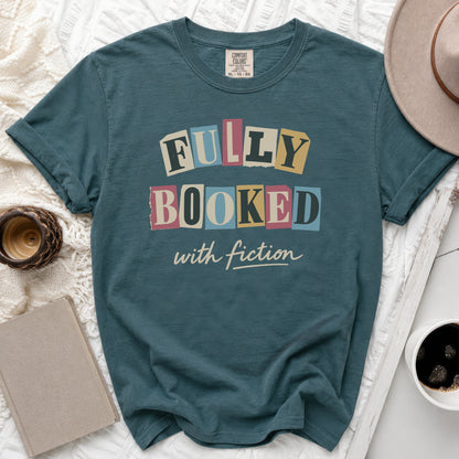 Teal t-shirt with "FULLY BOOKED with fiction" text in ransom note font.