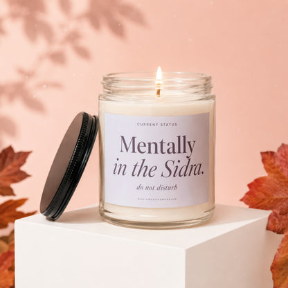 Candle in glass jar with black lid, labeled "Mentally in the Sidra. do not disturb."