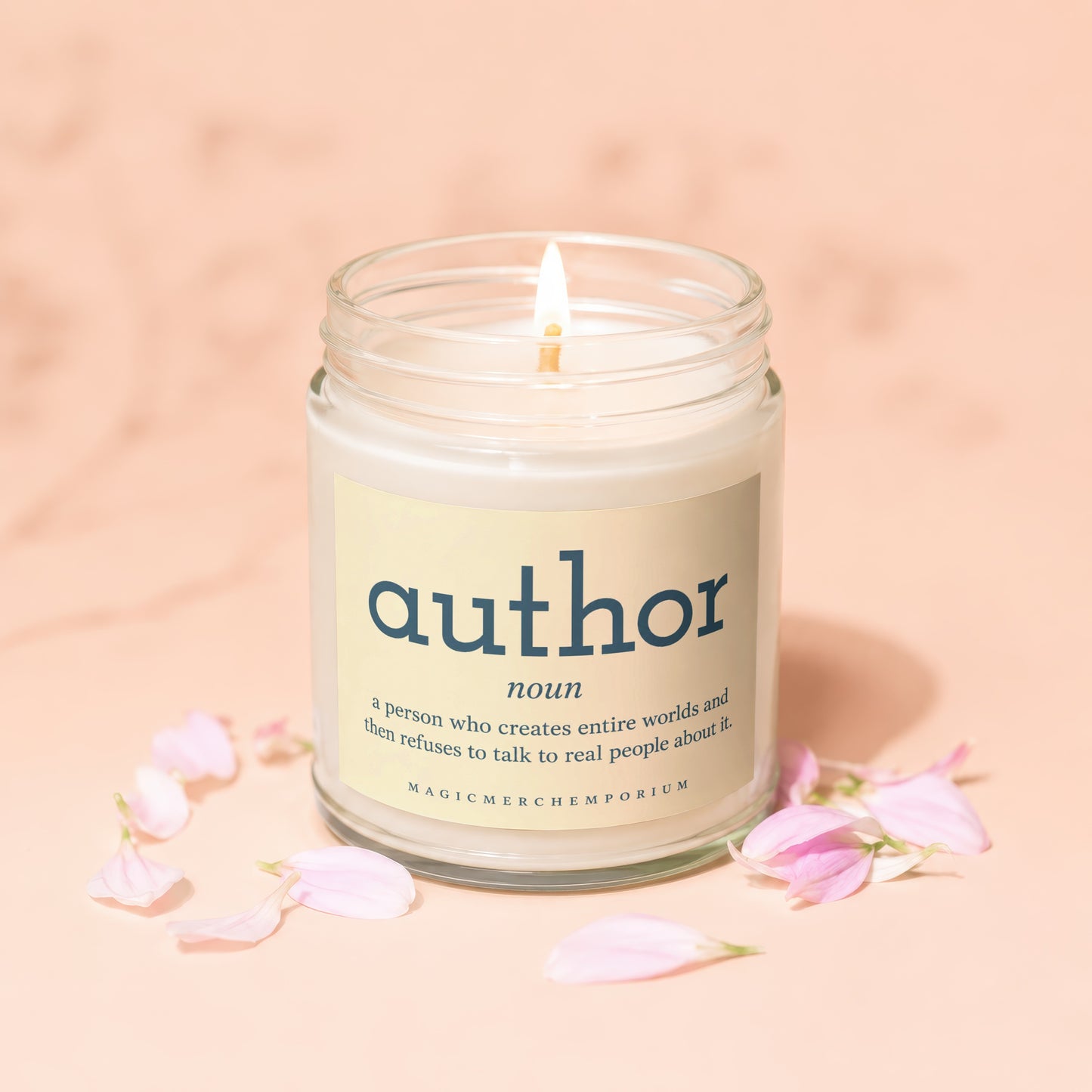 Lit candle with "author" definition label, surrounded by pink petals.