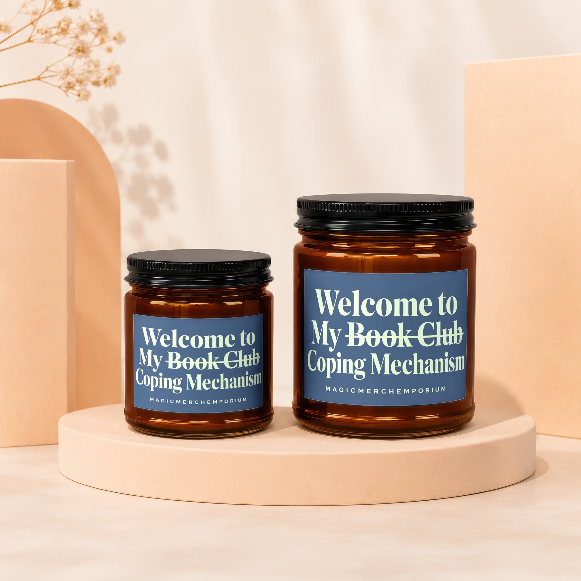 Two amber glass candles with blue labels, reading "Welcome to My Book Club Coping Mechanism".