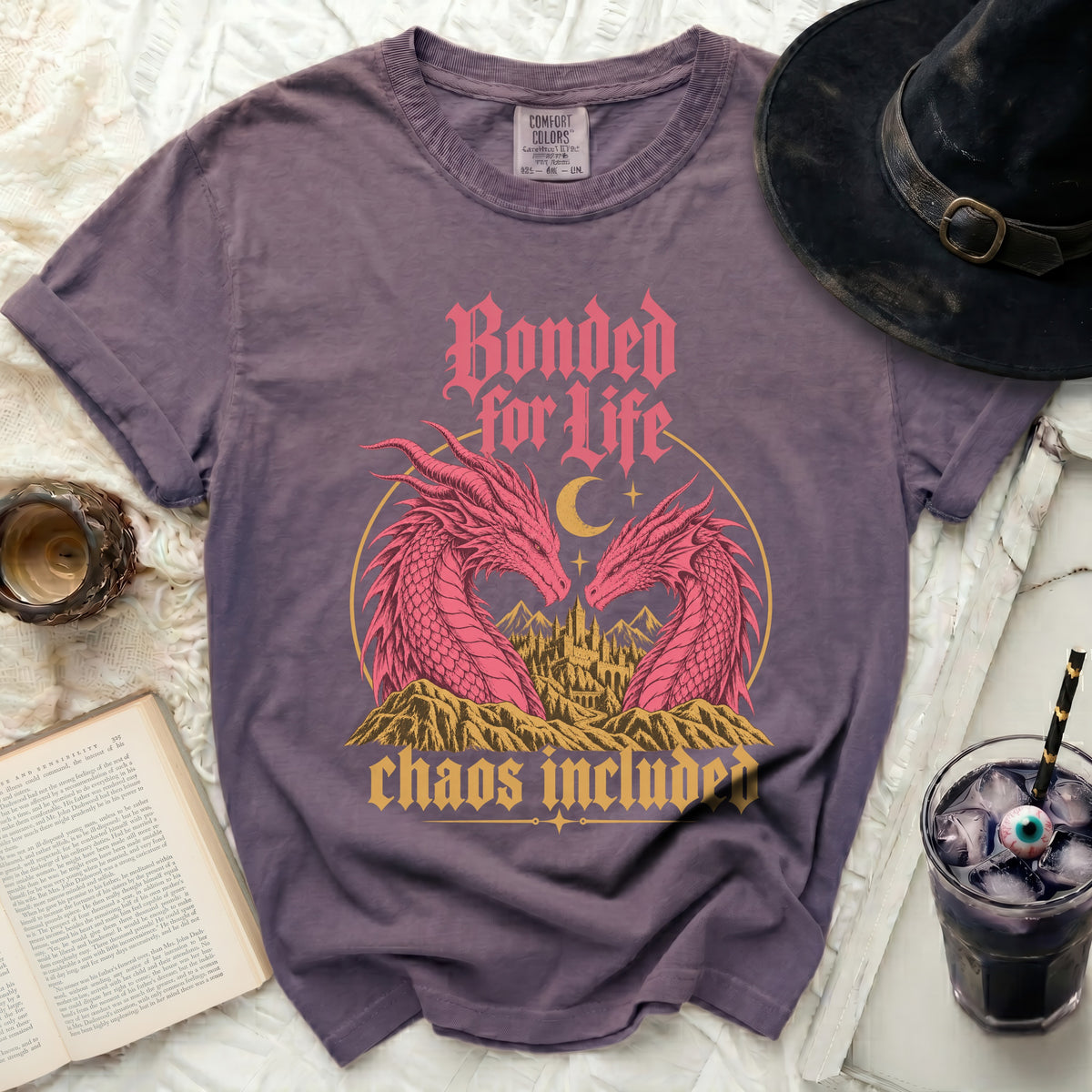 Purple t-shirt with pink dragons, castle, and text "Bonded for Life, chaos included."