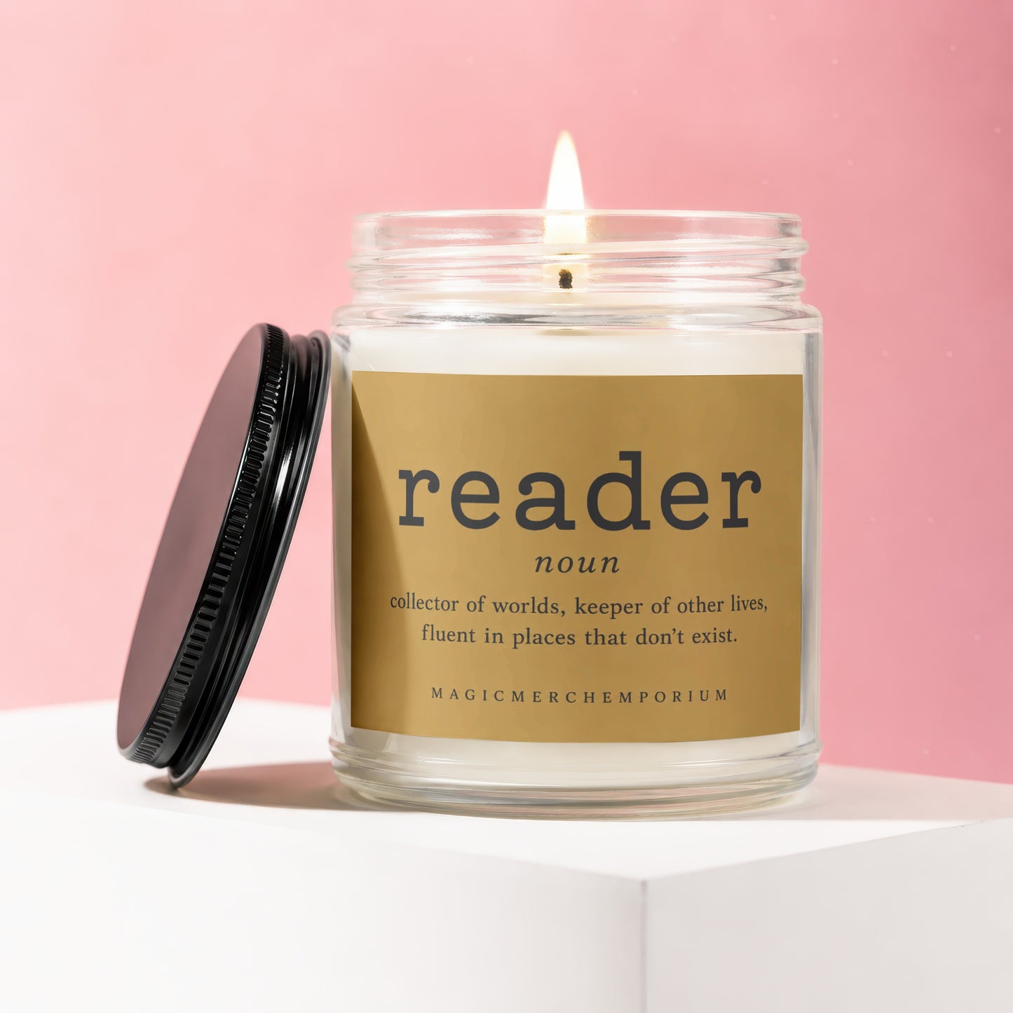 Candle with "reader noun collector of worlds" definition on label.