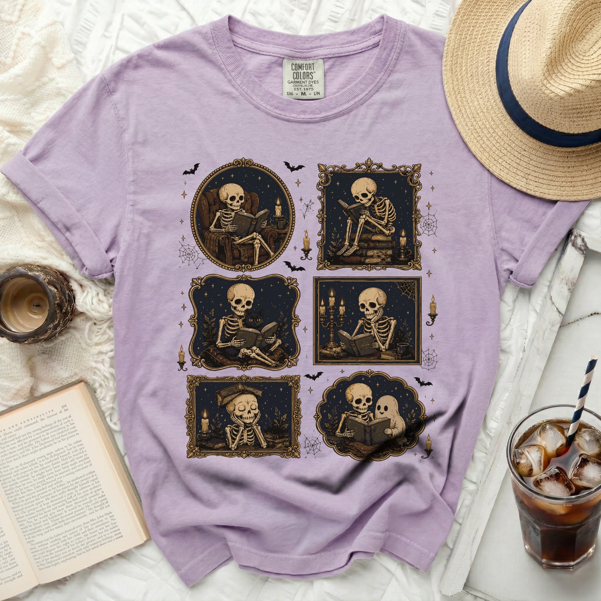Lilac t-shirt with a graphic of skeletons reading and a ghost.