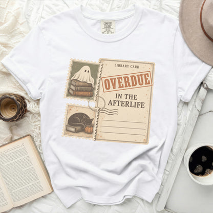White t-shirt with "Overdue In The Afterlife" library card graphic featuring ghost and black cat.