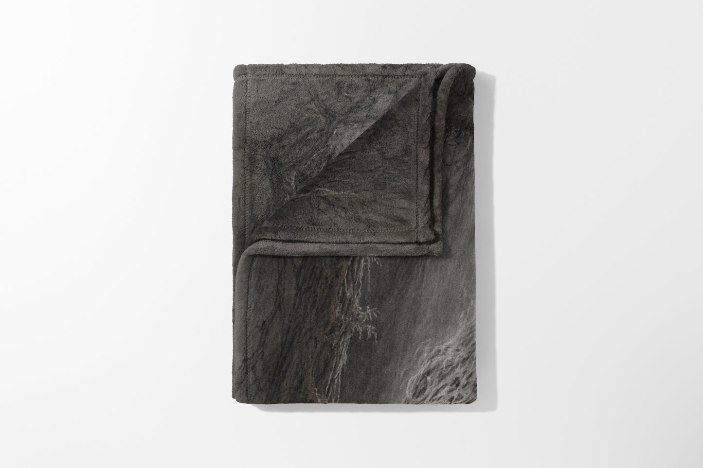 Folded grey blanket with a cracked stone pattern and a fuzzy texture.