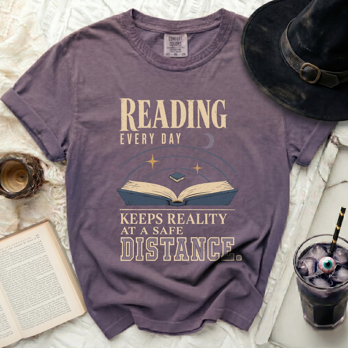 Purple t-shirt with "Reading Every Day Keeps Reality At A Safe Distance" text.