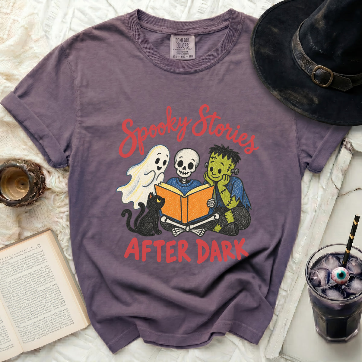 Purple t-shirt with "Spooky Stories AFTER DARK" and Halloween characters reading a book.