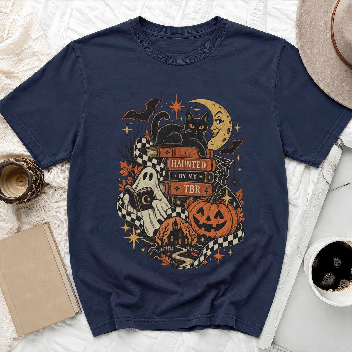 Navy t-shirt with Halloween graphic: black cat, ghost, pumpkin, and text "Haunted by my TBR".