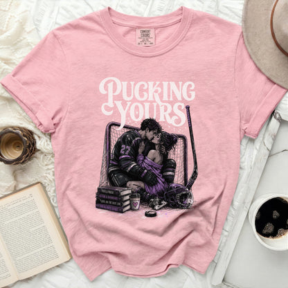 Pink t-shirt with "Pucking Yours" text and hockey couple illustration.