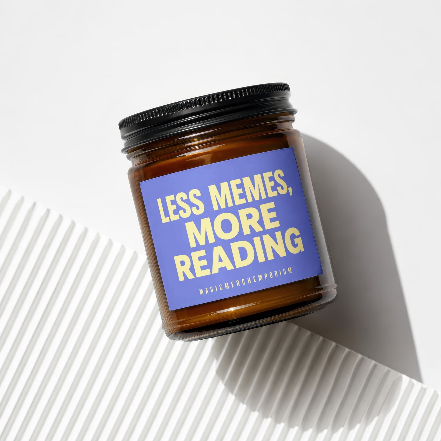 Amber jar candle with purple label reading "Less Memes, More Reading".