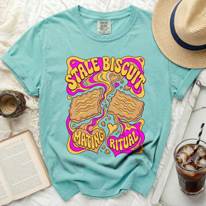 Teal t-shirt with "STALE BISCUIT MATING RITUAL" graphic and wavy lines.