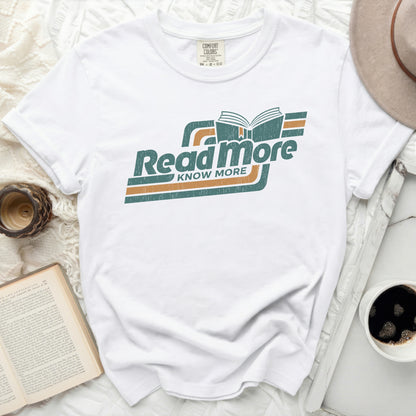 White t-shirt with "Read more KNOW MORE" graphic and an open book.