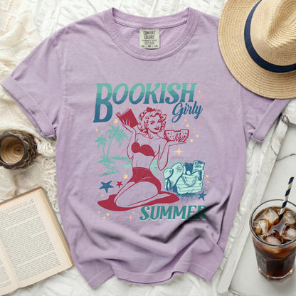 Lilac t-shirt with a graphic of a pin-up girl reading and eating watermelon.