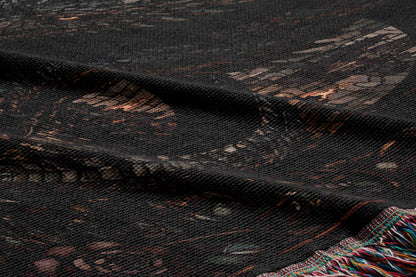 a close-up view of a dark-colored fabric with a patterned design, including a mix of geometric shapes and organic elements.