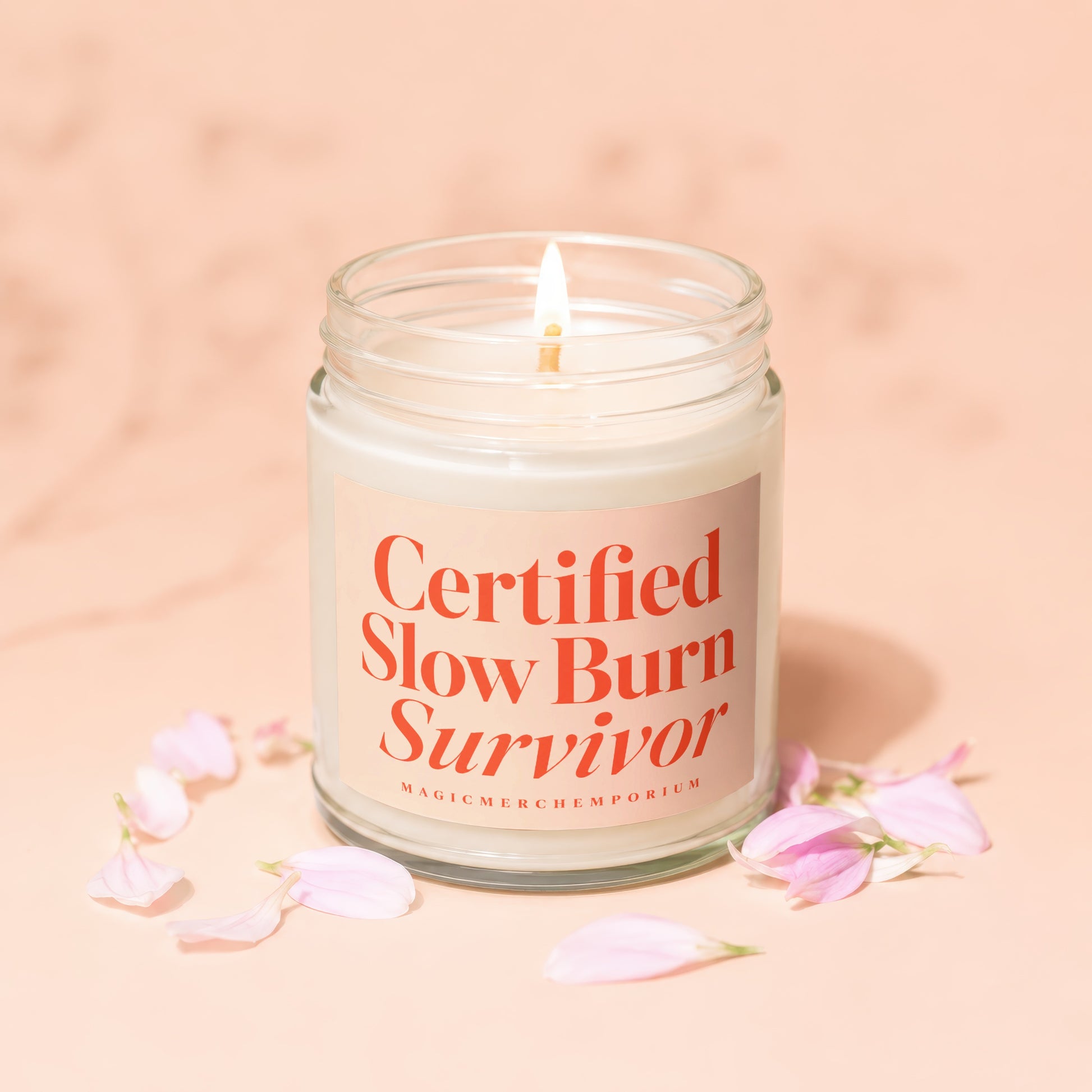Candle with lit wick, "Certified Slow Burn Survivor" text, and pink petals.