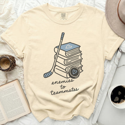 Cream t-shirt with stack of books, hockey stick, and puck.