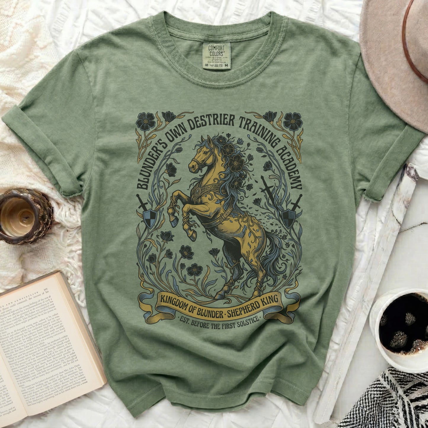 Green t-shirt with "Blunder's Own Destrier Training Academy" and horse graphic.
