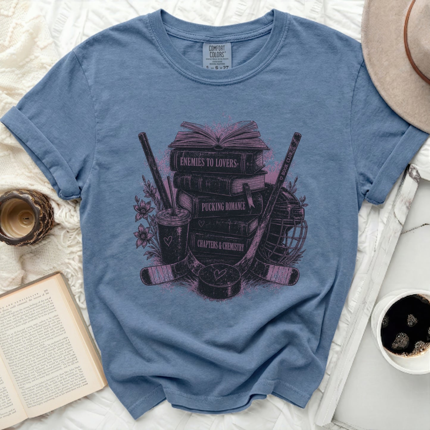 T-shirt with books, hockey sticks, and romantic novel themes.