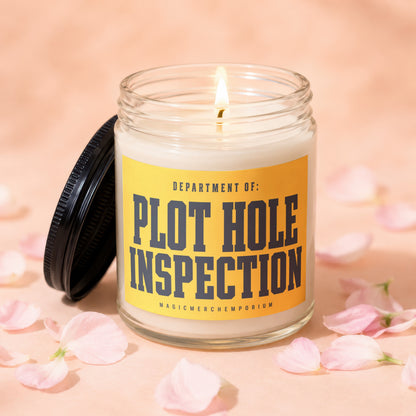Glass candle with lit wick and a yellow label reading "DEPARTMENT OF: PLOT HOLE INSPECTION".
