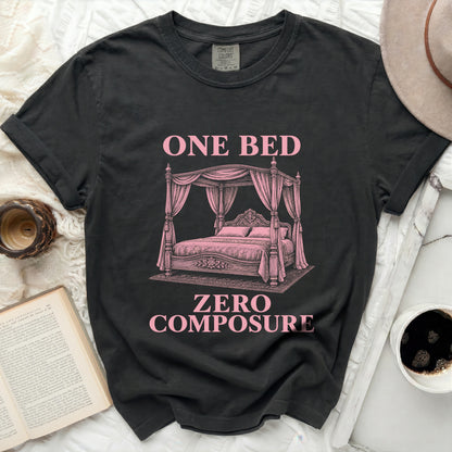 Dark t-shirt with pink text "ONE BED ZERO COMPOSURE" and a canopy bed graphic.